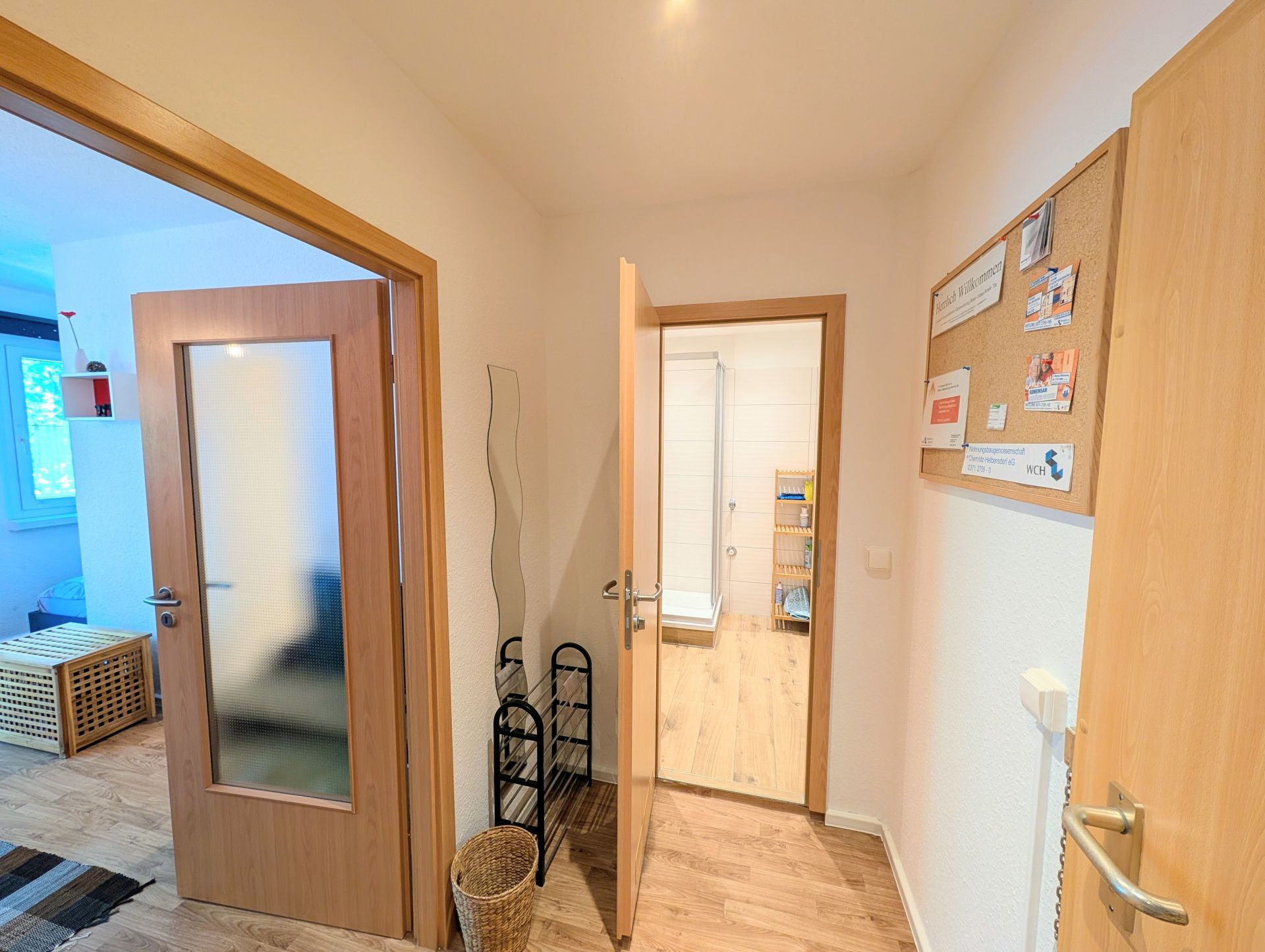 vorderer Teil des Flurs mit Blick ins Badezimmer sowie links seitlichem Blick ins Wohnzimmer