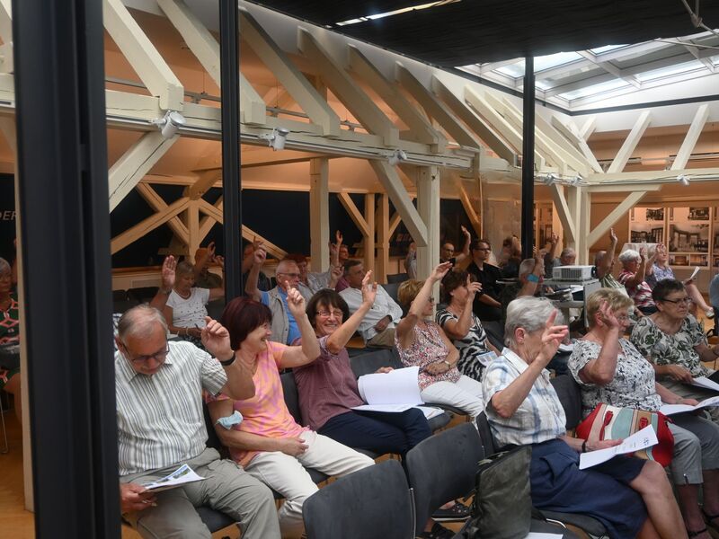 Genossenschaftsmitglieder bei der Abstimmung auf der jährlichen Mitgliederversammlung der Wohnungsgenossenschaft